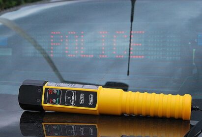 Na zdjęciu leżące na masce policyjnego radiowozu urządzenie do badani stanu trzeźwości